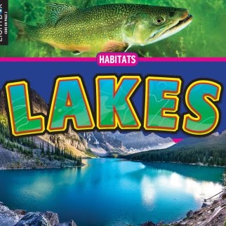 A book cover features a vibrant green and orange fish swimming in clear water at the top, a blue band with the word "Lakes" in large green and yellow letters in the middle, and a serene lake surrounded by mountains and evergreen trees at the bottom.