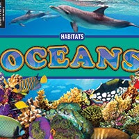 A book cover features two dolphins swimming near the surface of the ocean at the top, a blue band with the title "Oceans" in large yellow and blue letters in the middle, and a vibrant underwater scene with colorful coral and tropical fish at the bottom.
