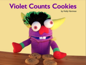 A purple friendly animal with four cookies