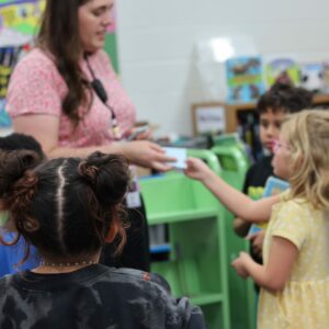 A librarian helps students find books in the library.