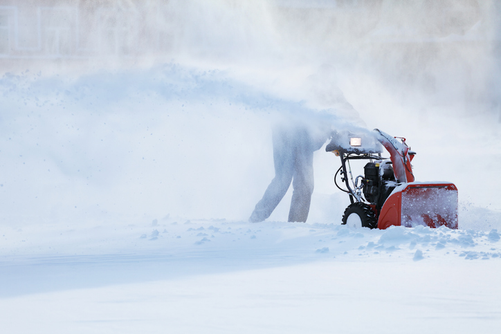 Photo of a person clearing snow with a snow plow