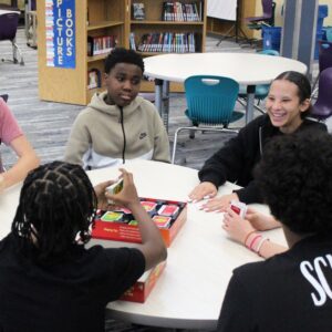 Hope Squad meeting of students playing games around a table.