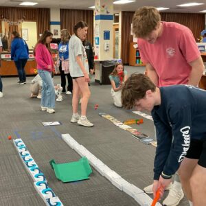Two students golf in the library