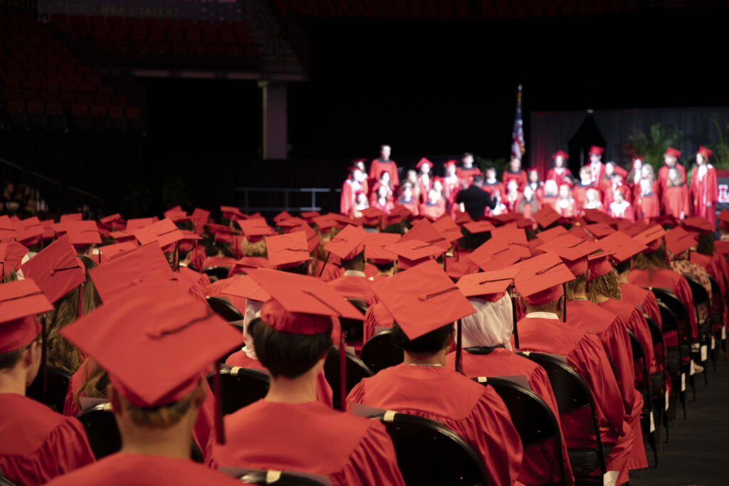 A sea of red caps as Lincoln High Graduates sit in Pinnacle Bank Arena listening to the choir.