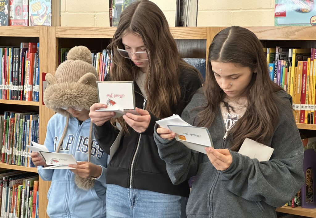 Three Goodrich Middle School students read thank you notes they received from North Gate Garden Estates residents.