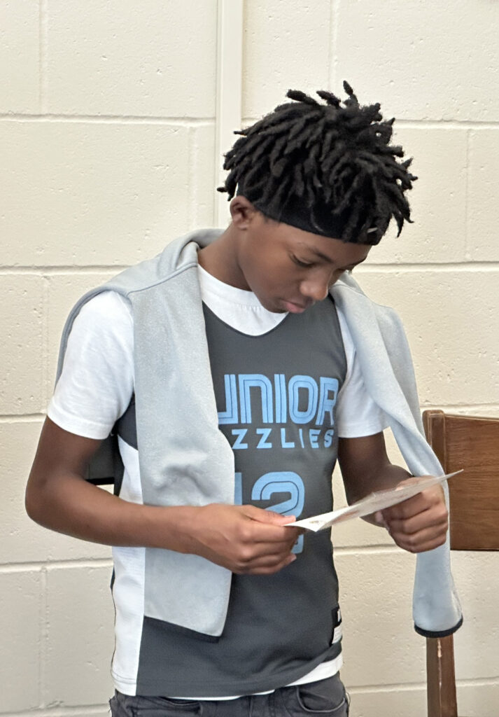 A Goodrich Middle School student reads a letter he received from a North Gate Garden Estates resident.