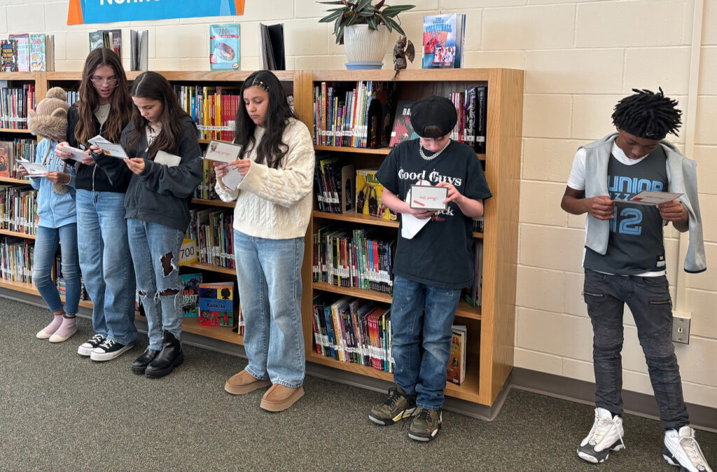 A group of sixth graders at Goodrich Middle School look at thank you notes they received from North Gate Garden Estates residents.