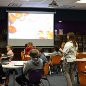 Students listen during instruction in the library.