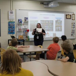 The librarian demonstrates a Wonderbook to a class.