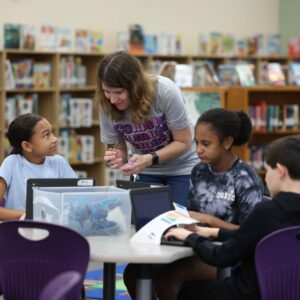 Mrs. Dorcey works with students at a table.