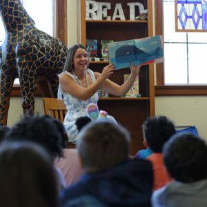 Mrs. Owens reading a book to a group of students.