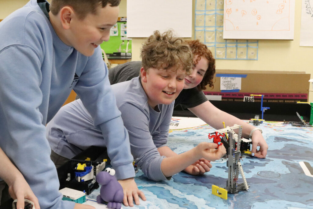 Students work together to solve a problem with Legos