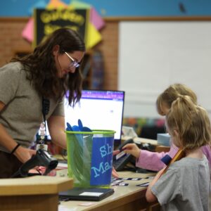 Mrs. Edwards helps students check out a book.