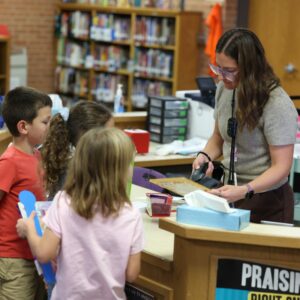 Students check out a book in the library.