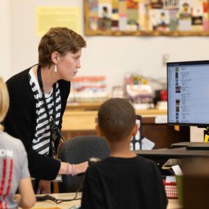 A student and Mrs. Reda look at the catalog on a computer.