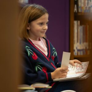 A student smiles while reading a book.