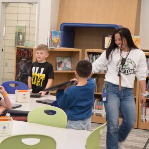 Mrs. Wright smiles while helping a group of students.