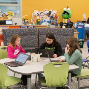 A group of students working at a library table.