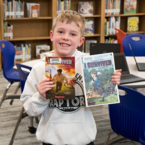 A student shows off their books they just checked out.