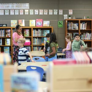 Mrs. Townsley helps students find books in the shelves.