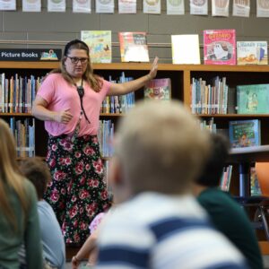Mrs. Townsley shows students the fiction section of the library.