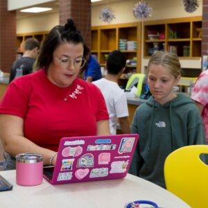 Mrs. Westphalen helps a student find a book in the online catalog.
