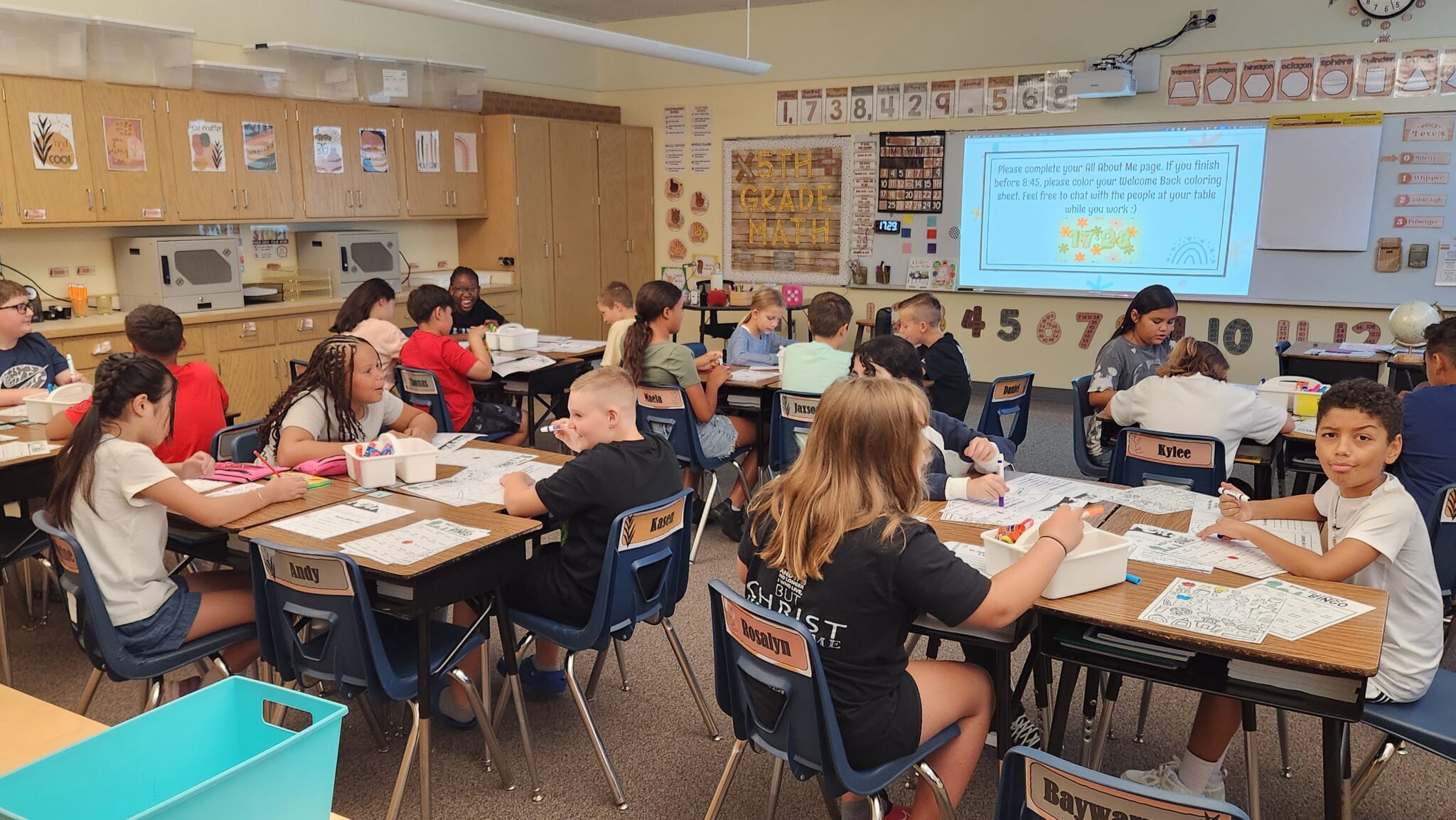 A full classroom of students creating All About Me pages on the first day of school